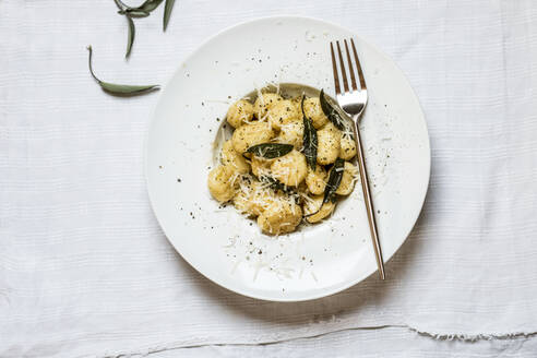 Plate of ready-to-eat Italian gnocchi dumplings with grated Parmesan cheese - SBDF04508