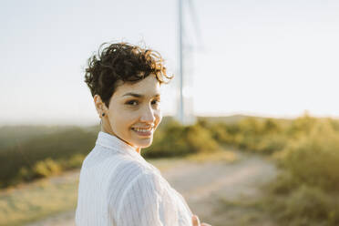 Smiling mid adult woman staring at sunset - GMCF00204