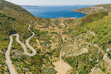 Luftaufnahme der kurvenreichen Straßen zur Stadt Komiza auf der Insel Vis, Dalmatien, Kroatien. - AAEF12486