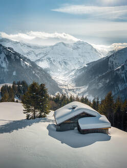 Luftaufnahme einer verschneiten Berghütte in Glarus im Winter - AAEF12494