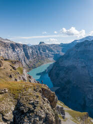 Luftaufnahme eines Wanderers am Rande einer Klippe im Schweizer Bergsee in Glarus, Schweiz. - AAEF12496