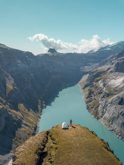 Luftaufnahme von Wanderer mit Zelt bewundern Blick auf Schweizer Bergsee in Glarus, Schweiz. - AAEF12499