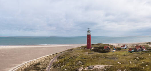 Luftaufnahme des Leuchtturms Vuurtoren am Strand an einem bewölkten Tag, De Cocksdorp, Nordholland, Niederlande. - AAEF12569