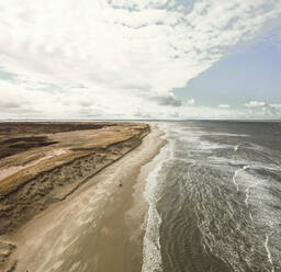 Luftaufnahme der Küstenlinie mit Wellen an einem bewölkten Tag mit Blick auf die Nordsee in der Region Nordholland, Niederlande. - AAEF12571