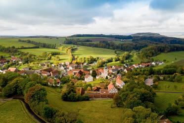 Luftaufnahme eines Dorfes in einem Tal der Rhön im Herbst, Hessen, Deutschland. - AAEF12630