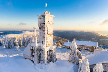 Luftaufnahme eines schneebedeckten Turms und von Skihütten in den Bergen, Schwarzwald, Deutschland. - AAEF12668