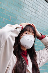 Young woman wearing protective face mask during COVID-19 - ASGF00960