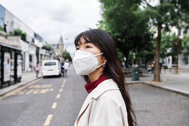 Nachdenkliche Frau mit Gesichtsschutzmaske in der Stadt - ASGF00962