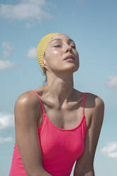 Frau trägt rosa ein Stück Badeanzug beim Sonnenbaden auf sonnigen Tag - VPIF04438