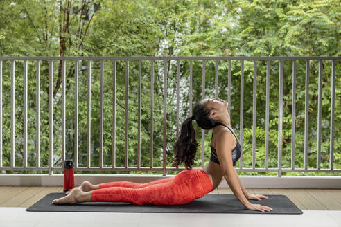 Female athlete doing Urdhva Mukha Svanasana at balcony - EAF00028