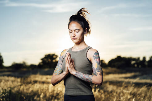 Frau meditiert beim Yoga auf dem Lande - DAMF00890