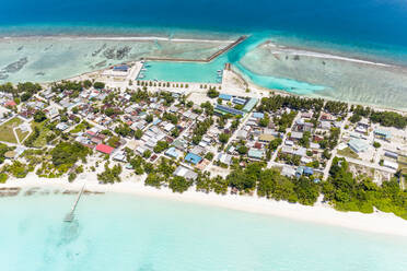 Panoramablick aus der Luft auf die lokale, bewohnte Insel Vashafaru mit Lagune, Riff und Hafen, Malediven. - AAEF12688
