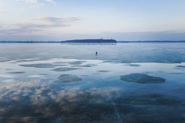 Luftaufnahme eines Fischers auf einem zugefrorenen See im Frühling, Kaunas, Litauen. - AAEF12821