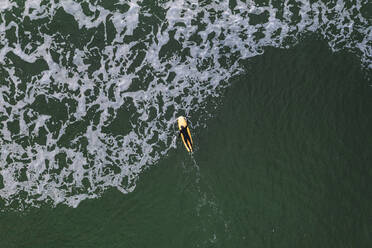 Luftaufnahme eines Surfers, der auf einem Surfbrett in der Nähe von Klaipeda, Litauen, auf die Ostsee hinaus paddelt. - AAEF12859