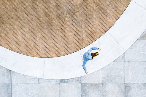 Aerial top down view of skateboarder riding in public area in Kaunas city, Lithuania. - AAEF12910