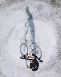 Luftaufnahme der Silhouette eines BMX-Radfahrers auf einer Betonfläche in Panevezys, Litauen. - AAEF12933