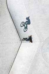 Aerial view of BMX bike rider doing a jump trick in local skatepark near Panevezys, Lithuania. - AAEF12938