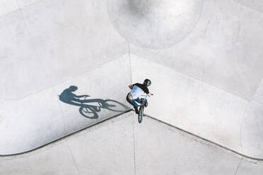 Aerial view of BMX bike rider doing turn down trick in local skatepark in Panevezys, Lithuania. - AAEF12939