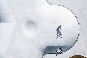 Aerial view of BMX bike rider silhouette shadow in concrete skate pool, Panevezys, Lithuania. - AAEF12950