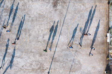 Kaunas, Lithuania - 18 April 2021: Aerial top down view of players shadows in urban basketball court in Kaunas, Lithuania. - AAEF12956