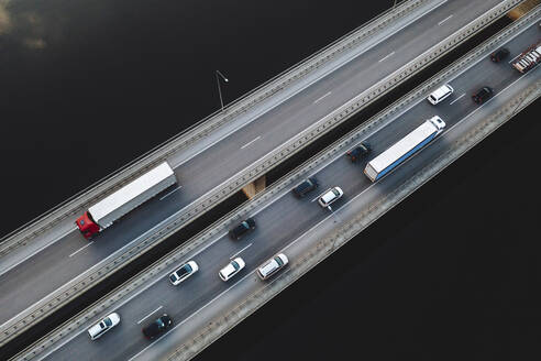 Aerial view of traffic vehicles driving on the highway bridge over the Neman river in Kaunas, Lithuania. - AAEF12969