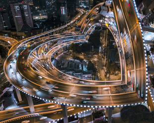 Luftaufnahme einer belebten Straße mit komplexer Kreuzung bei Nacht in der Innenstadt von Shanghai, China. - AAEF13096