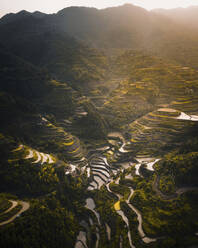 Luftaufnahme einer Reisterrasse bei Sonnenuntergang entlang des Bergkamms bei Sonnenaufgang, Dorf Dong, Guizhou, China. - AAEF13098