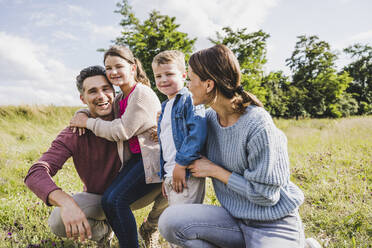 Children with by parents at meadow - UUF24241