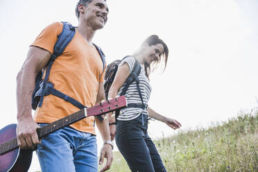 Mann hält Gitarre beim Wandern mit Frau - UUF24272