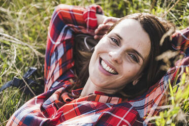 Happy woman resting on grass - UUF24293