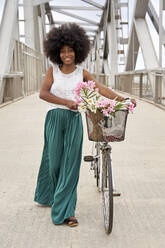 Afro-Frau zu Fuß mit Fahrrad auf Brücke - VEGF04800