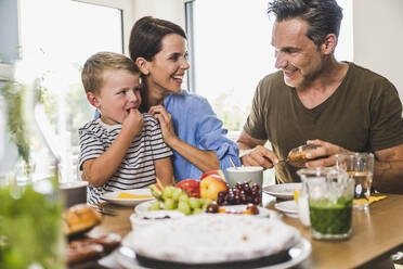 Glückliche Familie beim Frühstück zu Hause - UUF24492