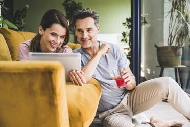 Couple using digital tablet while sitting at home - UUF24544