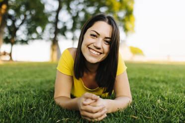 Glückliche junge Frau entspannt sich im Gras im Park - XLGF02175