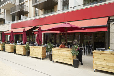 Couple sitting under parasol at sidewalk cafe - PMF02067