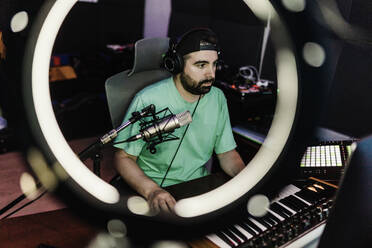 Professioneller DJ spielt Synthesizer, während er im Studio Musik komponiert - XLGF02191