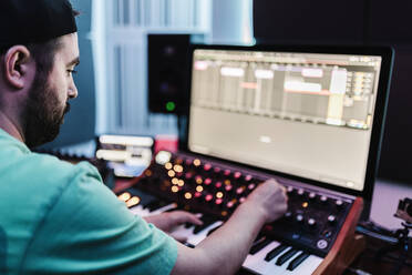 Male composer mixing sound in studio - XLGF02195