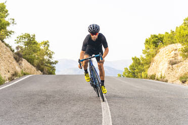 Männlicher Sportler, der auf der Straße Rad fährt - DLTSF02071