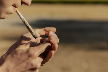 Jugendlicher zündet Marihuana-Joint bei Sonnenuntergang an - ACPF01266