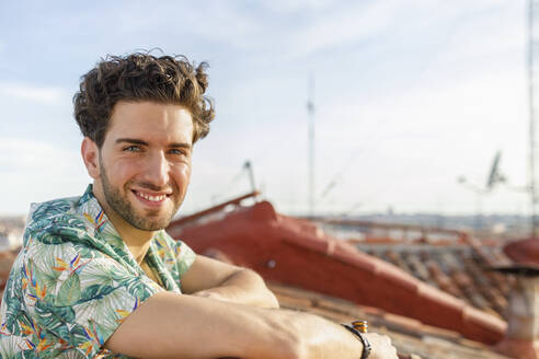Lächelnder junger Mann auf der Terrasse am Wochenende - IFRF00991