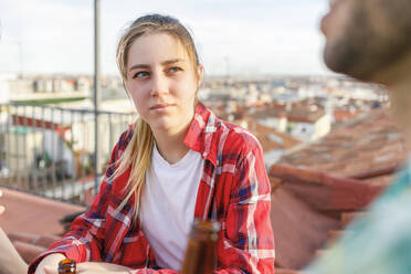 Junge Frau sieht männlichen Freund auf dem Dach an - IFRF01012