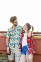 Young couple looking at each other during party on rooftop - IFRF01035