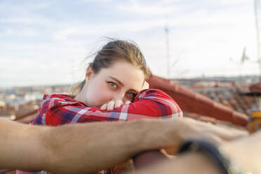 Young woman leaning on railing at rooftop - IFRF01038