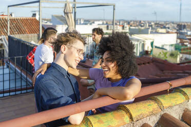 Fröhliche multiethnische Freunde stehen zusammen auf der Terrasse - IFRF01047