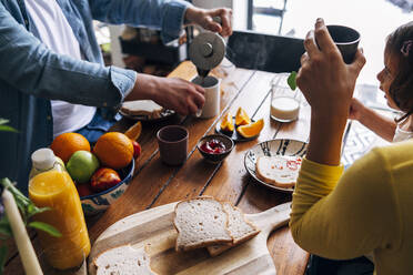 Mann bereitet Kaffee zu, während er mit seiner Familie zu Hause frühstückt - ASGF01006