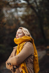 Woman with arms crossed during autumn - JOSEF05369