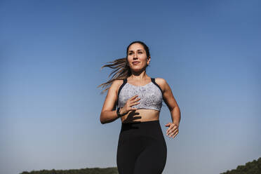 Weibliche Athletin läuft bei Sonnenuntergang - EBBF04504