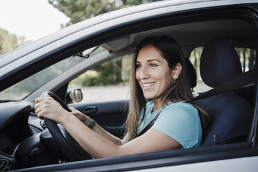 Smiling beautiful woman driving car - EBBF04541