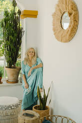 Ältere Frau entspannt sich an einer weißen Wand zu Hause - ERRF04951