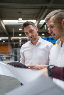 Geschäftsmann bei der Besprechung eines Dokuments mit Kollegen in der Industrie - DIGF16162